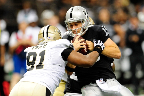 NEW ORLEANS, LA - AUGUST 16:  Matt Flynn #15 of the Oakland Raiders is sacked by Will Smith #91 of the New Orleans Saints during a preseason game at the Mercedes-Benz Superdome on August 16, 2013 in New Orleans, Louisiana.  (Photo by Stacy Revere/Getty Images)